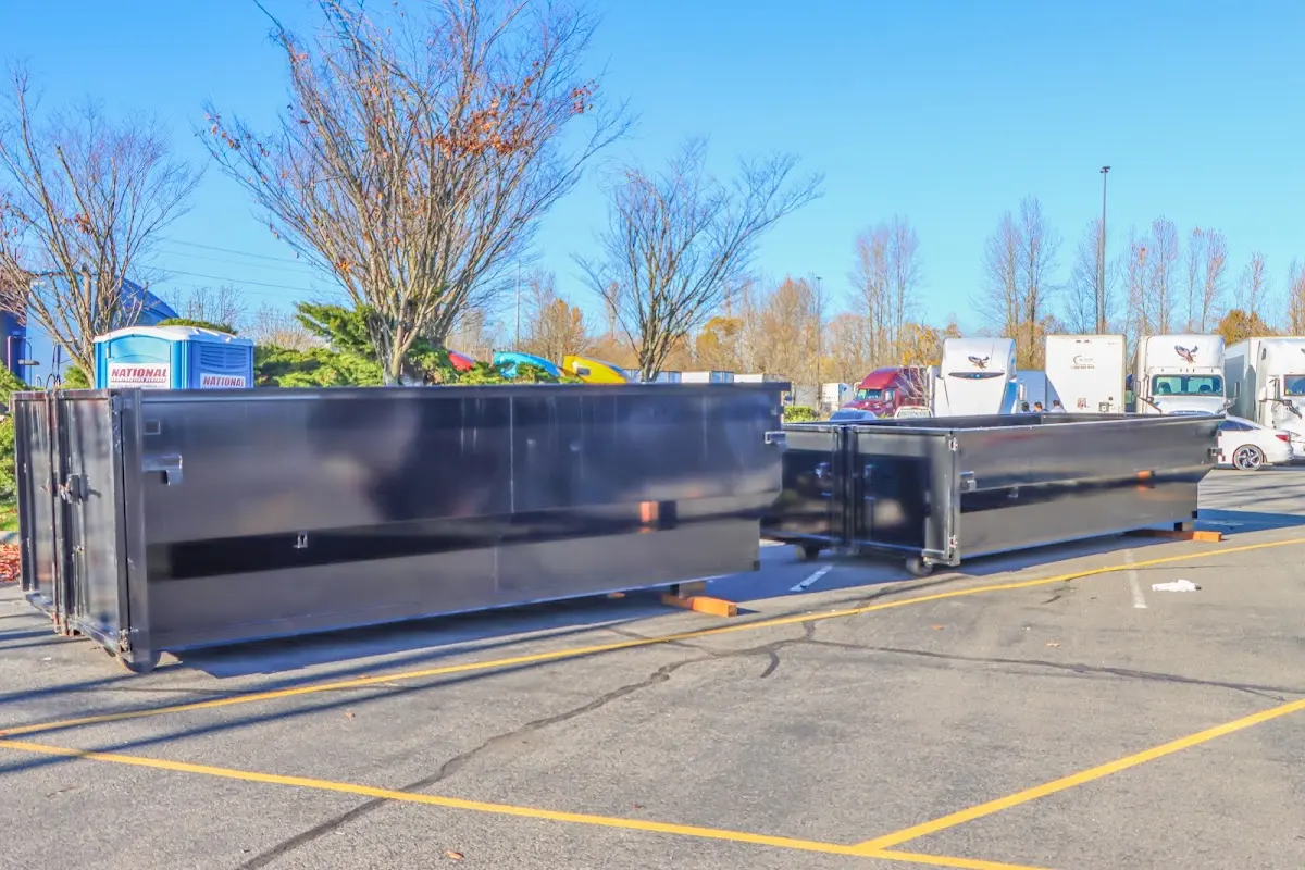 Professional dumpster rental service with roll-off container on residential driveway in Raisinville